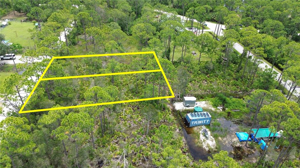 An aerial view shows two adjacent wooded lots outlined in yellow near a residential area — 28381 HERMOSO DRIVE, PUNTA GORDA, FL