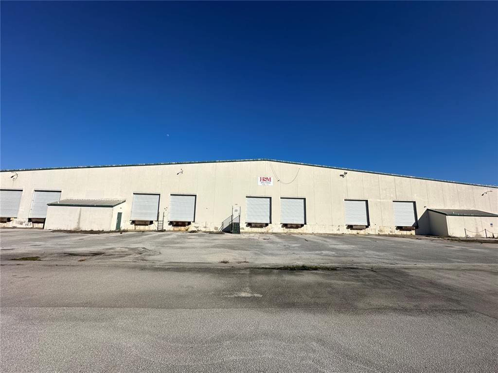 A large industrial warehouse building features multiple loading docks and a paved parking lot — 5407 NW 44TH AVENUE, OCALA, FL
