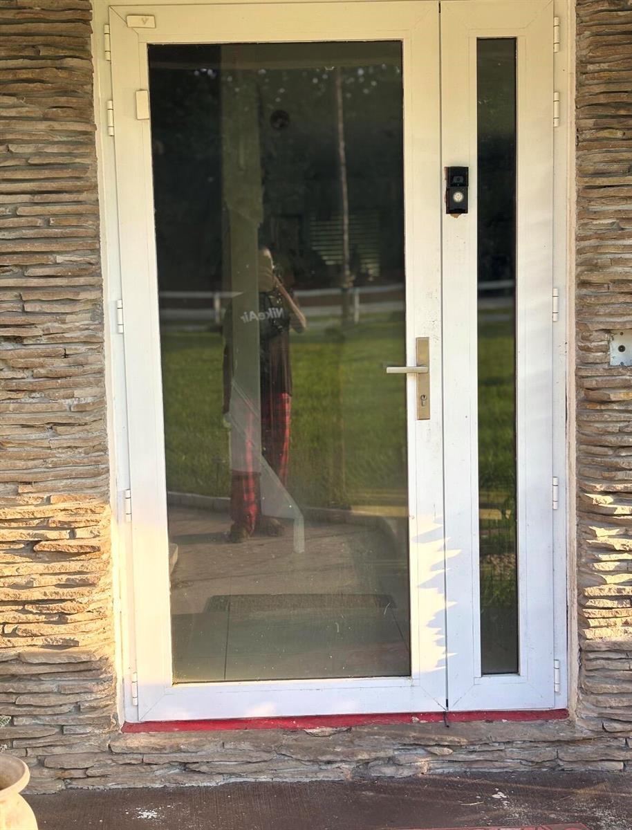 A white-framed glass front door with a side light and a doorbell camera — 11852 61st Street N, FL 33412, FL