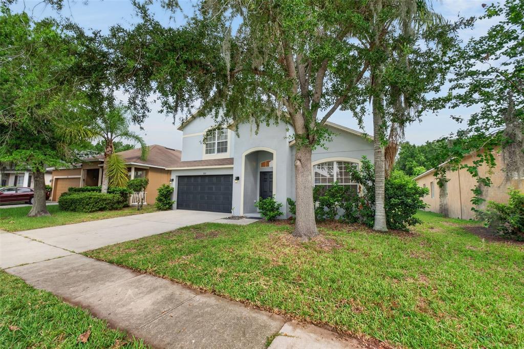 A two-story house with a gray exterior, a dark garage door, and a front lawn — 1851 GREAT FALLS WAY, ORLANDO, FL