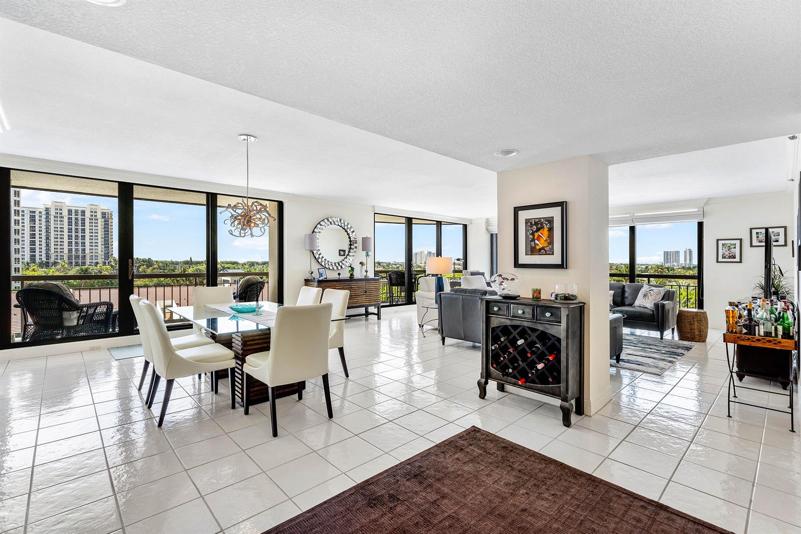 An open-concept living and dining area features white tile floors, floor-to-ceiling windows, and balcony views — 4100 N Ocean Drive # 504, Singer Island FL 33404, SINGER ISLAND, FL