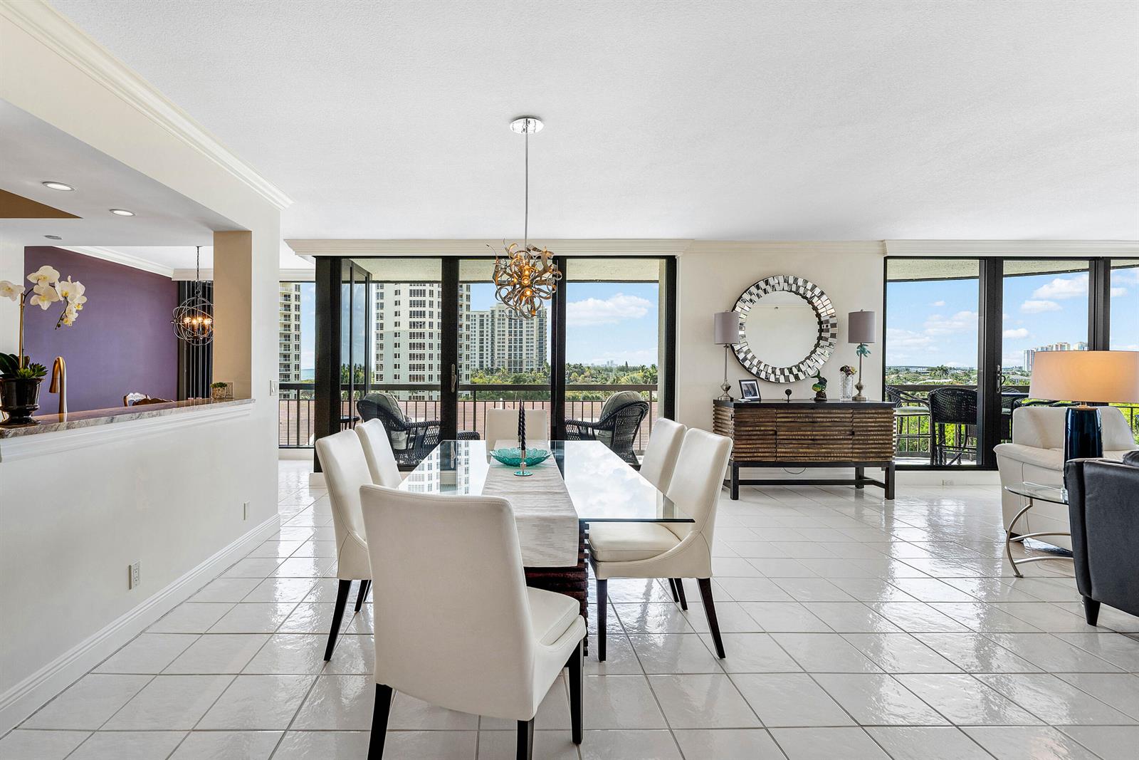 A dining area with a glass table, white chairs, and tile floors overlooks a balcony — 4100 N Ocean Drive # 504, Singer Island FL 33404, SINGER ISLAND, FL