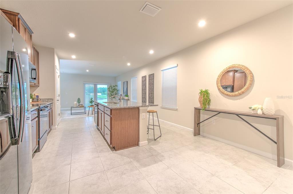 A kitchen with a center island, stainless steel appliances, and a console table against the wall — 11836 BRISTOL BRIDGE ROAD, SPRING HILL, FL