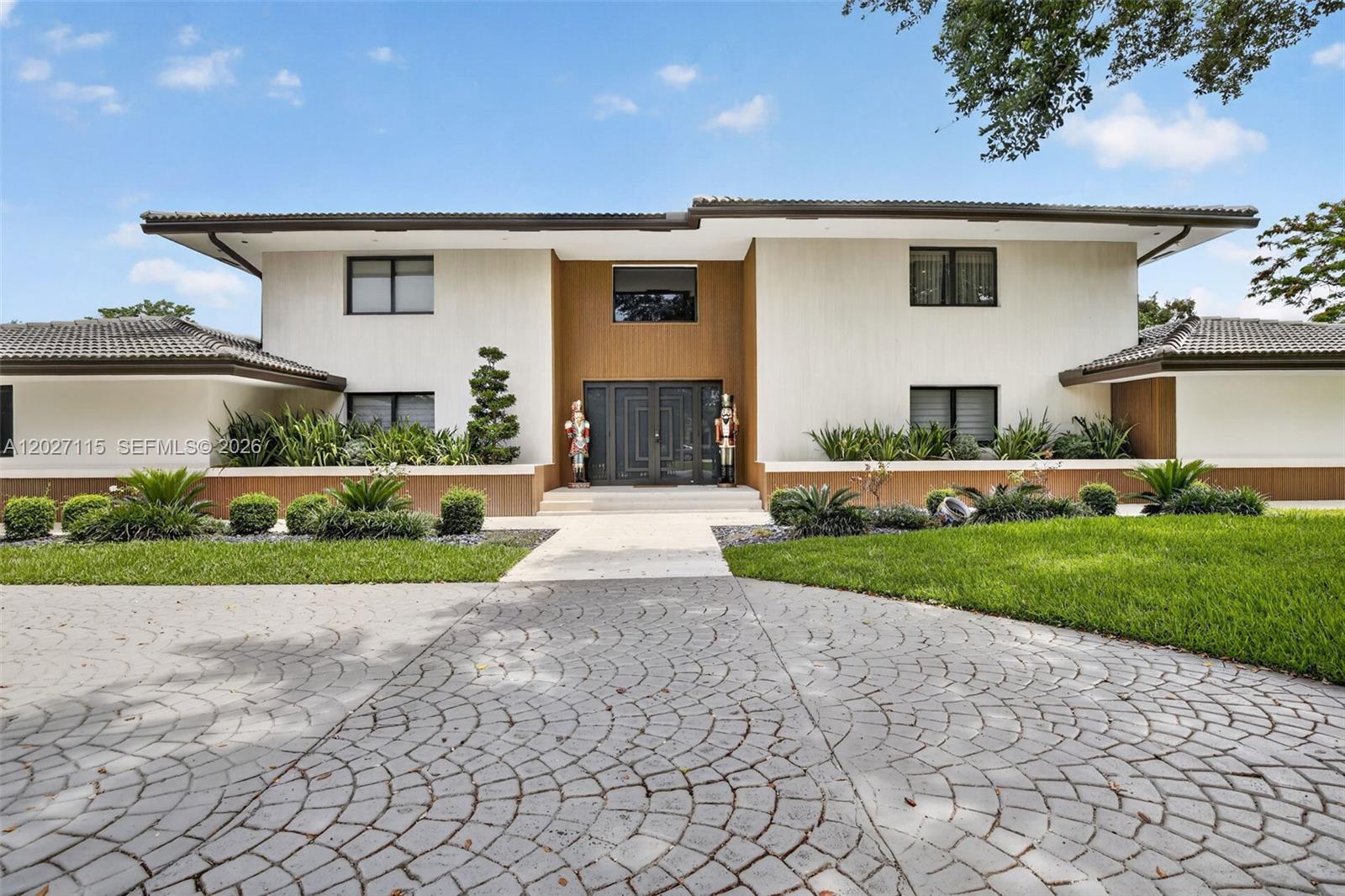 A two-story house features a paved circular driveway, a central entrance, and landscaped garden beds — 12111 NW 5th Ct, Plantation FL 33325, PLANTATION, FL