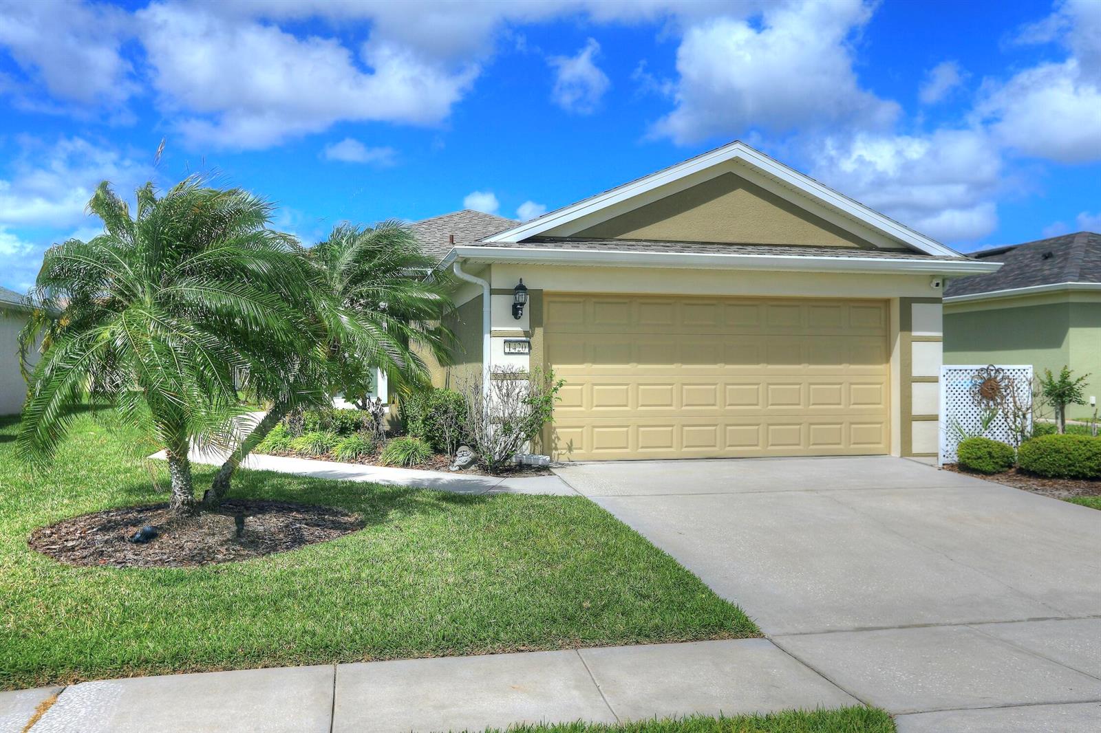 A single-story house with a beige garage, a palm tree, and a concrete driveway — 1420 Dittmer Circle SE, Palm Bay FL 32909, PALM BAY, FL