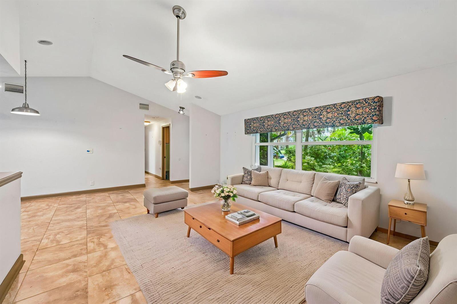 A living room features a beige sofa, a wooden coffee table, and tile flooring — 255 SW Salerno Road, Stuart FL 34997, STUART, FL