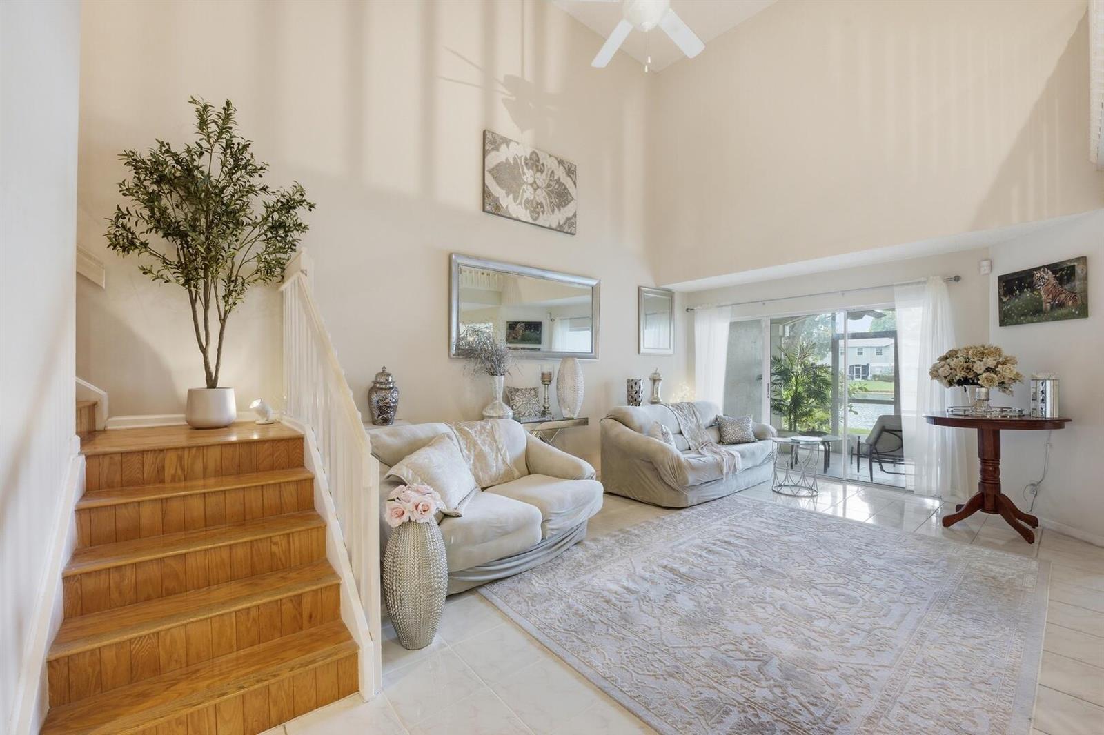 A living room with high ceilings, a staircase, two sofas, and a large area rug — 9172 Boca Gardens Parkway # B, Boca Raton FL 33496, BOCA RATON, FL