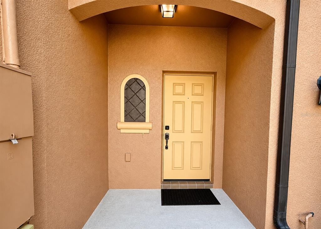 The exterior entryway features a tan door, an arched window, and a concrete porch — 1720 RETREAT VIEW CIRCLE, SANFORD, FL