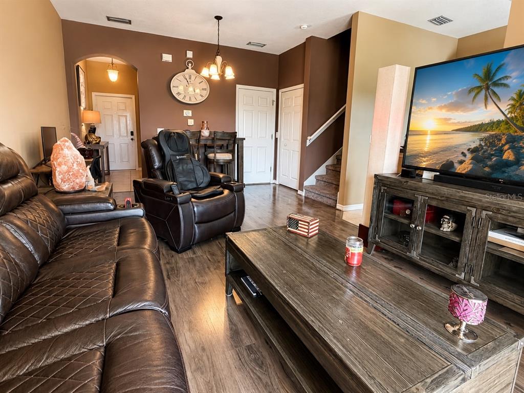 A living room with dark leather furniture, a wooden coffee table, and a large television — 1720 RETREAT VIEW CIRCLE, SANFORD, FL