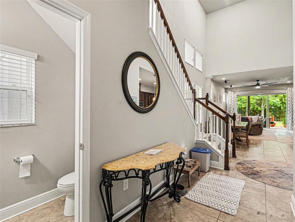 An entryway with a staircase, a console table, a mirror, and a view into the living area — 7508 SEA LILLY COURT, APOLLO BEACH, FL