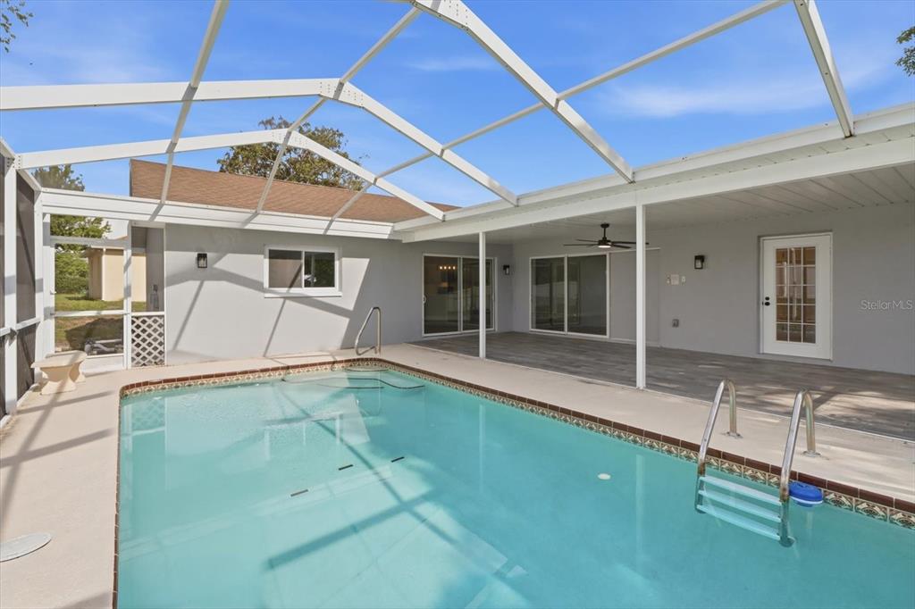 A dining room with a wooden table, woven chairs, and a kitchen island nearby — 9642 ELGIN BOULEVARD, SPRING HILL, FL