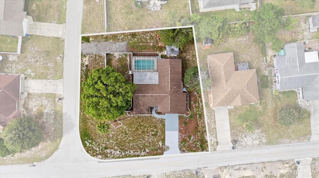 A screened-in swimming pool patio features a covered lanai with tile flooring and sliding doors — 9642 ELGIN BOULEVARD, SPRING HILL, FL