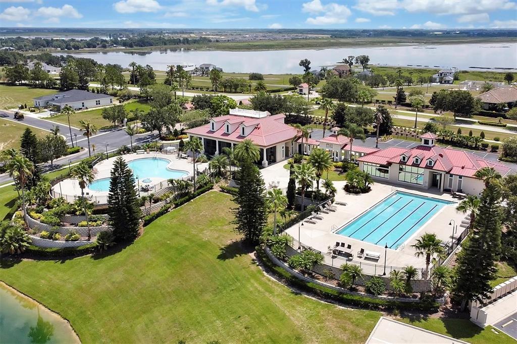 An aerial view shows a community clubhouse with two swimming pools and landscaped grounds — 168 FRINGE TREE, LAKE ALFRED, FL