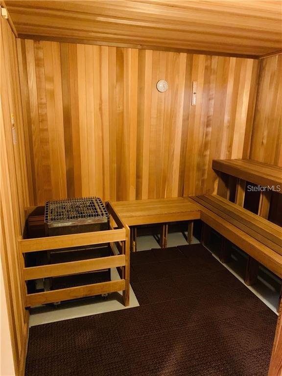 A cedar-paneled sauna features a heater with a wooden guard and tiered wooden benches — 168 FRINGE TREE, LAKE ALFRED, FL