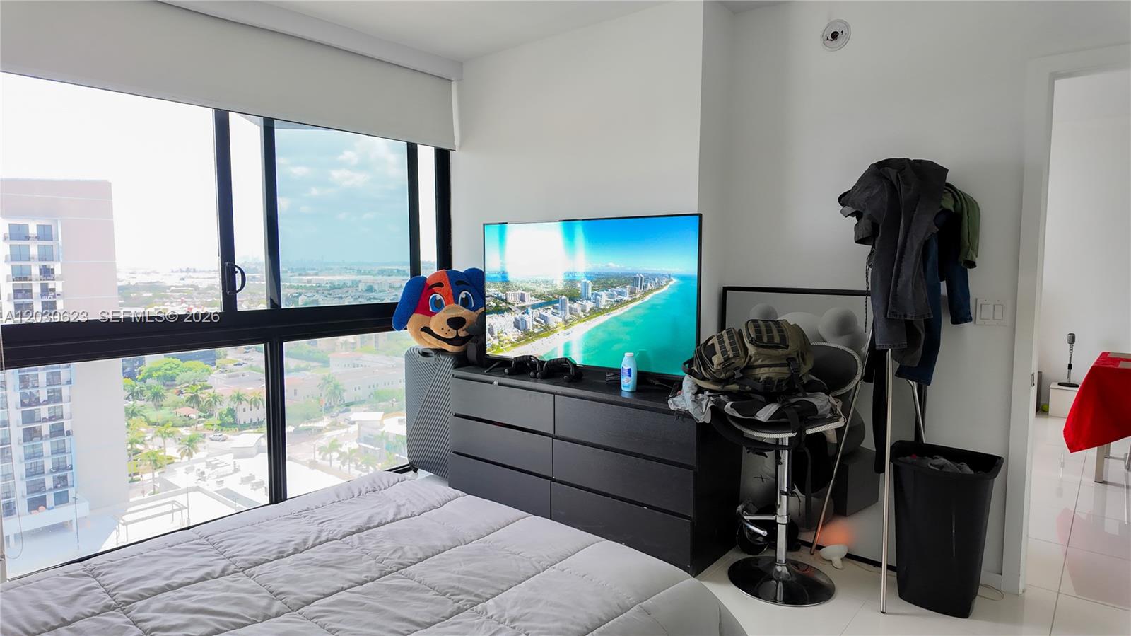 A bedroom features a black dresser, a television, a bed, and a large window view — 5300 Paseo Blvd # 1807, Doral FL 33166, DORAL, FL