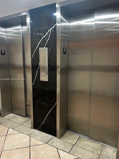 Two stainless steel elevator doors are set into a wall with black marble paneling — 801 NW 47th Ave # 717W, Miami FL 33126, MIAMI, FL