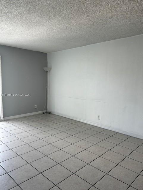 An empty room features light-colored tile flooring, a gray accent wall, and a white wall — 801 NW 47th Ave # 717W, Miami FL 33126, MIAMI, FL