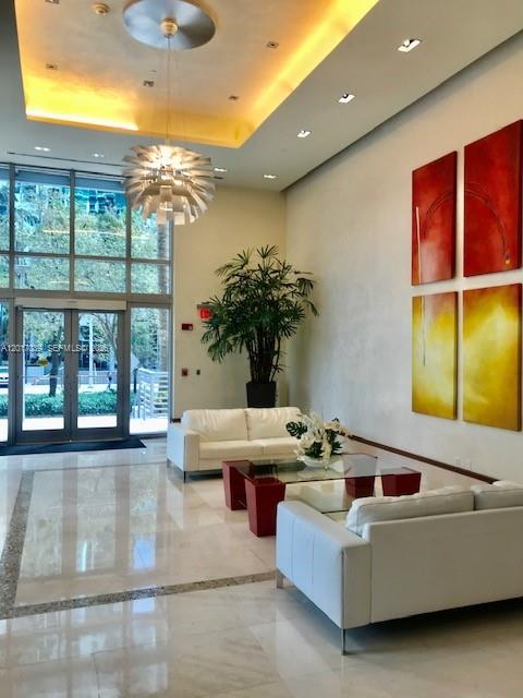 A view of a living area with light wood flooring and a sliding glass door — MIAMI, FL