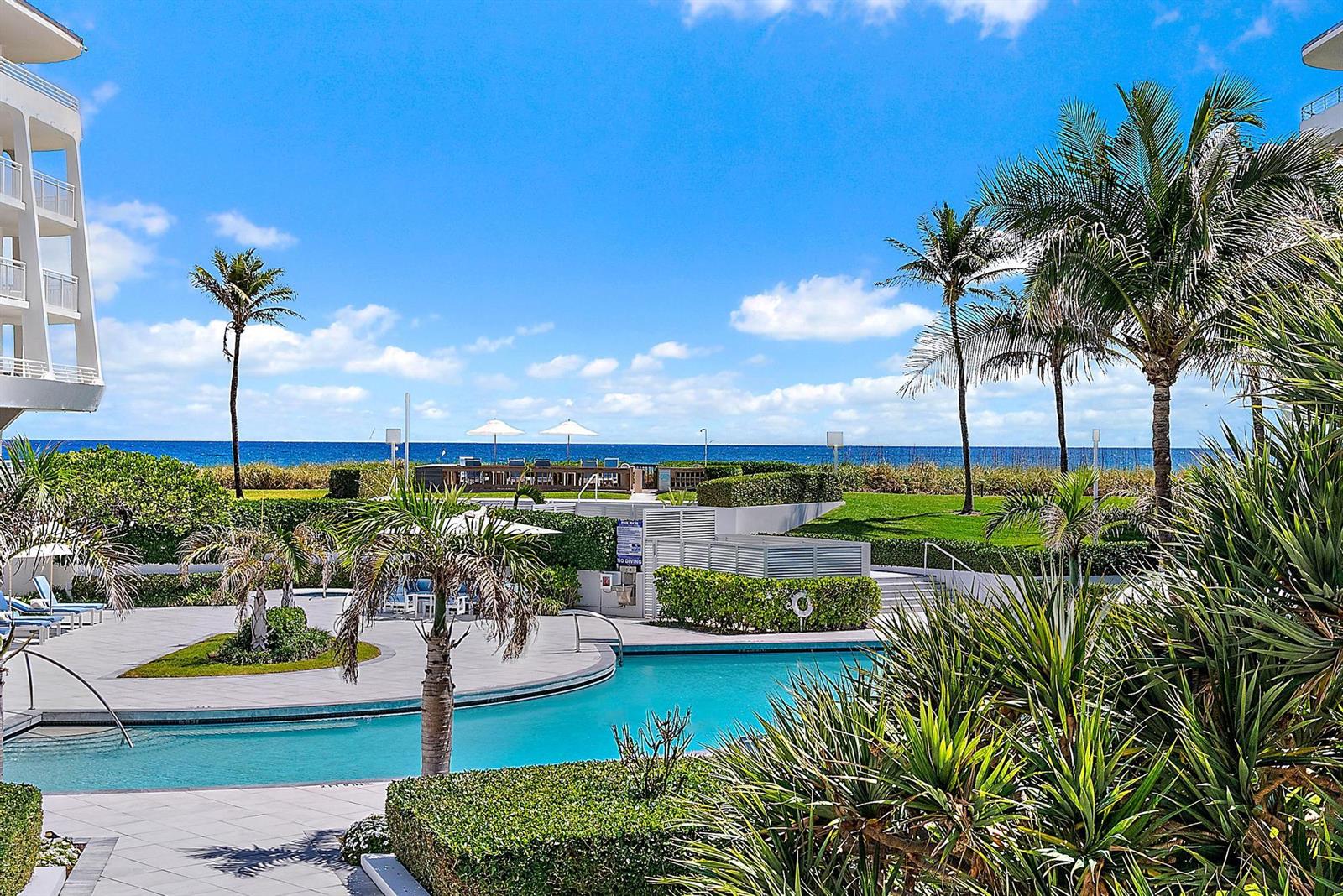 A swimming pool area with palm trees and landscaping overlooking the ocean — 2600 S Ocean Boulevard # 102w, Palm Beach FL 33480, PALM BEACH, FL