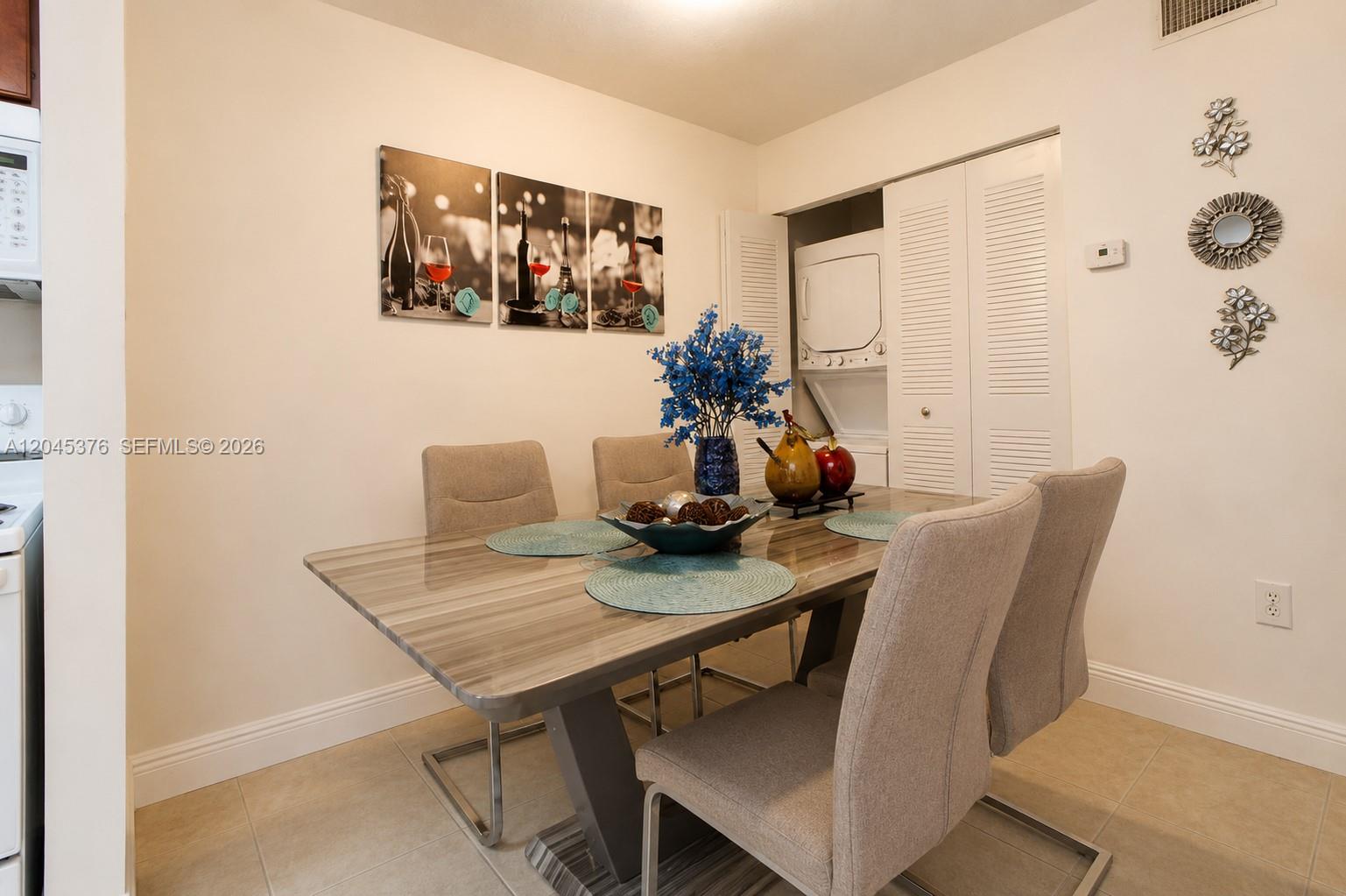 A dining area features a modern table with four chairs and a laundry closet — 7090 NW 179th St # 108, Hialeah FL 33015, HIALEAH, FL