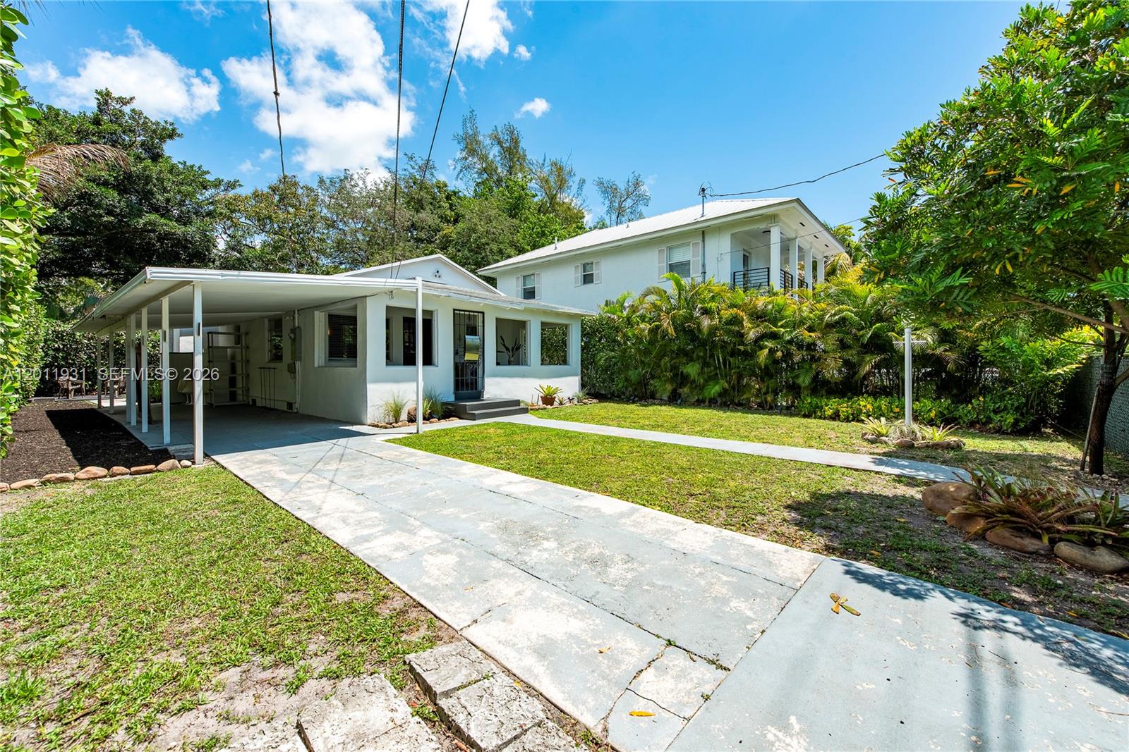 A white single-story house with a carport and a concrete driveway sits on a lawn — 3655 Oak Ave # 3655, Miami FL 33133, MIAMI, FL