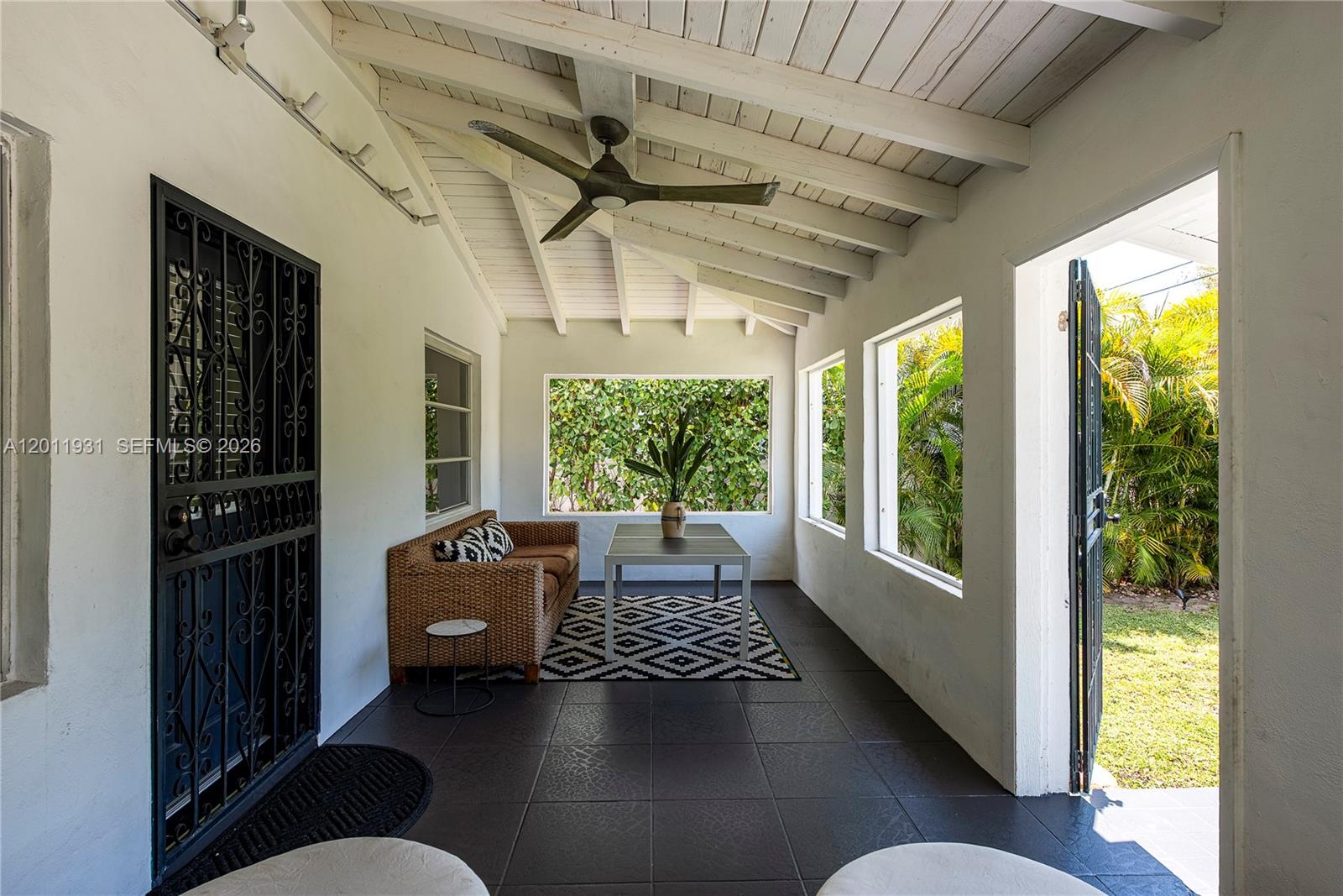 A covered patio features dark tile flooring, a wicker sofa, and a ceiling fan — 3655 Oak Ave # 3655, Miami FL 33133, MIAMI, FL