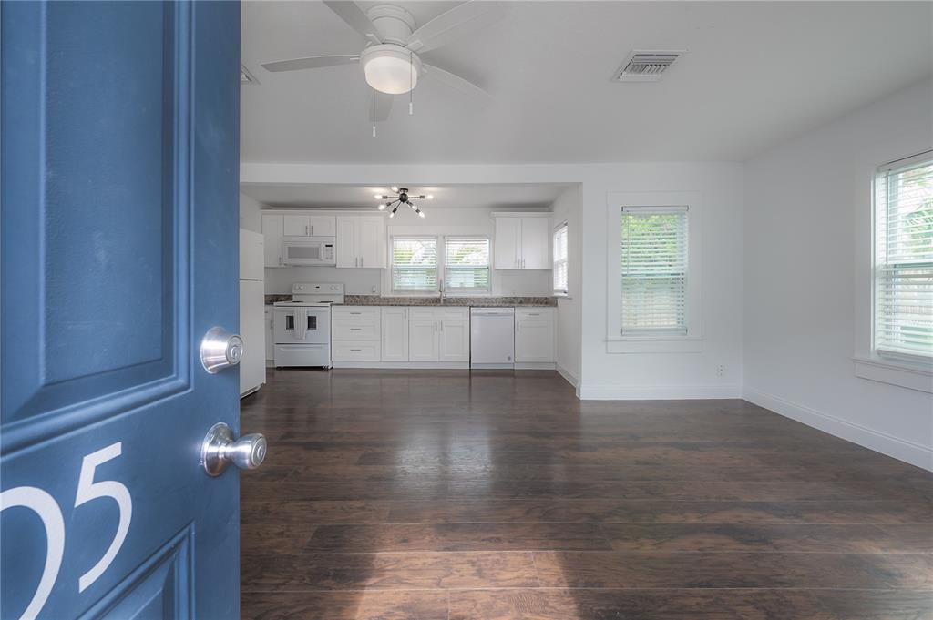 A view from a doorway into an open-concept kitchen with white cabinets and wood flooring — 405 E CAYUGA STREET, TAMPA, FL