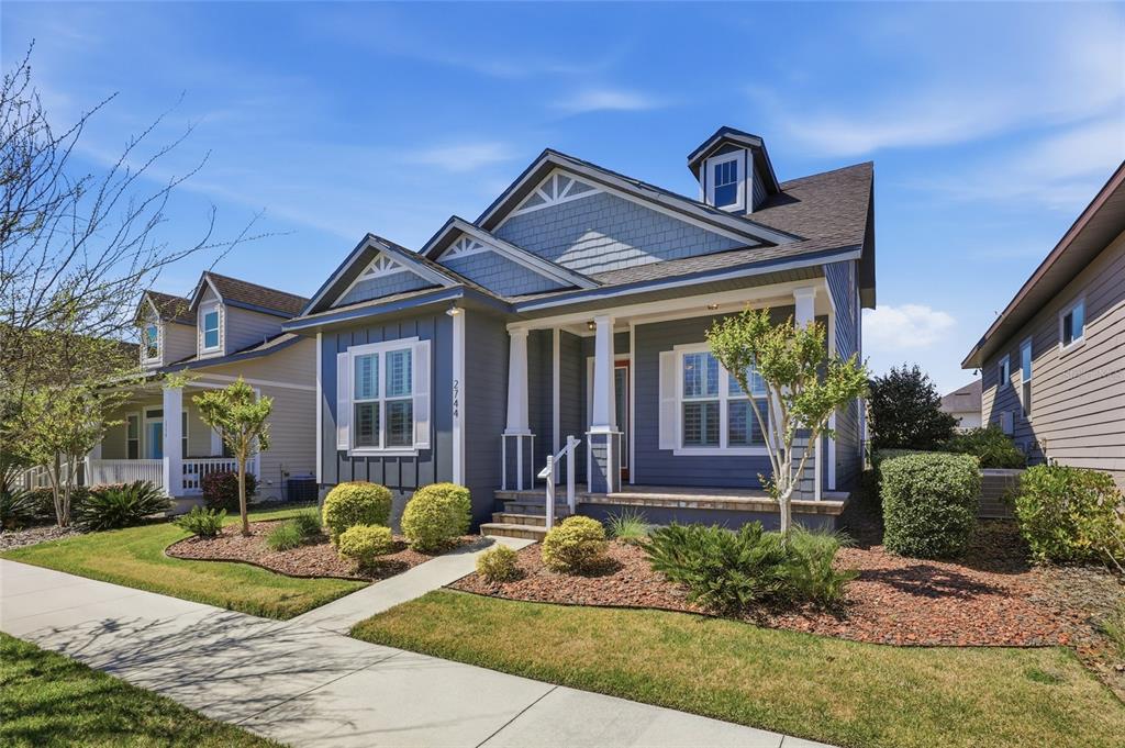 A blue, single-story house with a front porch, white trim, and a shingled roof — 2744 SW 118TH TERRACE, GAINESVILLE, FL