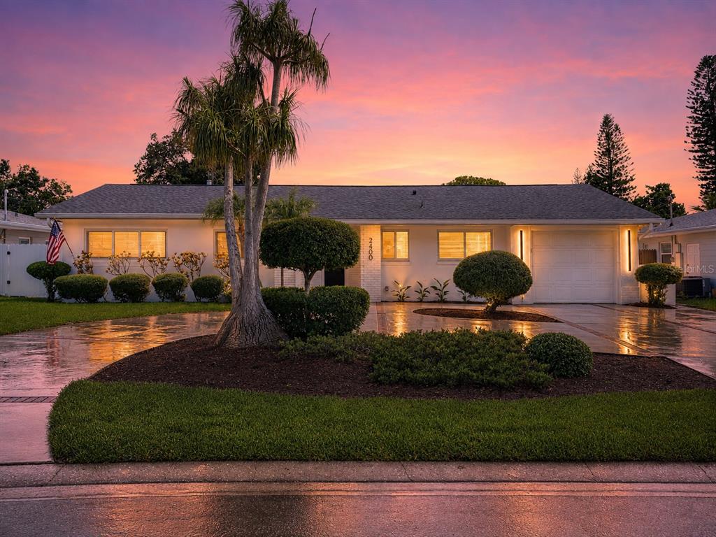 A bright, open-concept living area features a vaulted ceiling with a wood beam and kitchen — 2400 66TH TERRACE S, ST PETERSBURG, FL