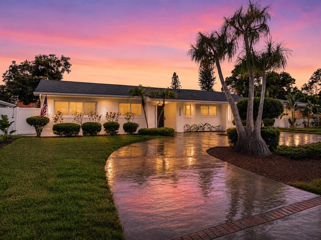 A kitchen features white cabinets, granite countertops, a red tiled backsplash, and stainless steel appliances — 2400 66TH TERRACE S, ST PETERSBURG, FL