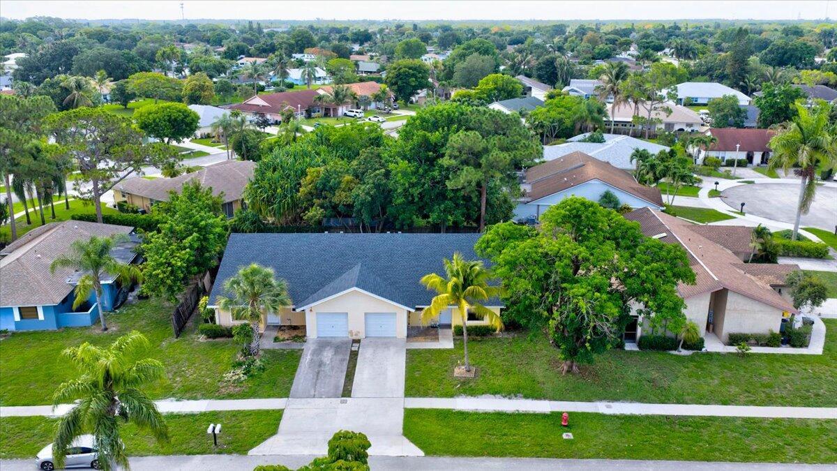 An aerial view of a single-story suburban house with a dark roof and two garages — 12452 Guilford Way, Wellington FL 33414, WELLINGTON, FL