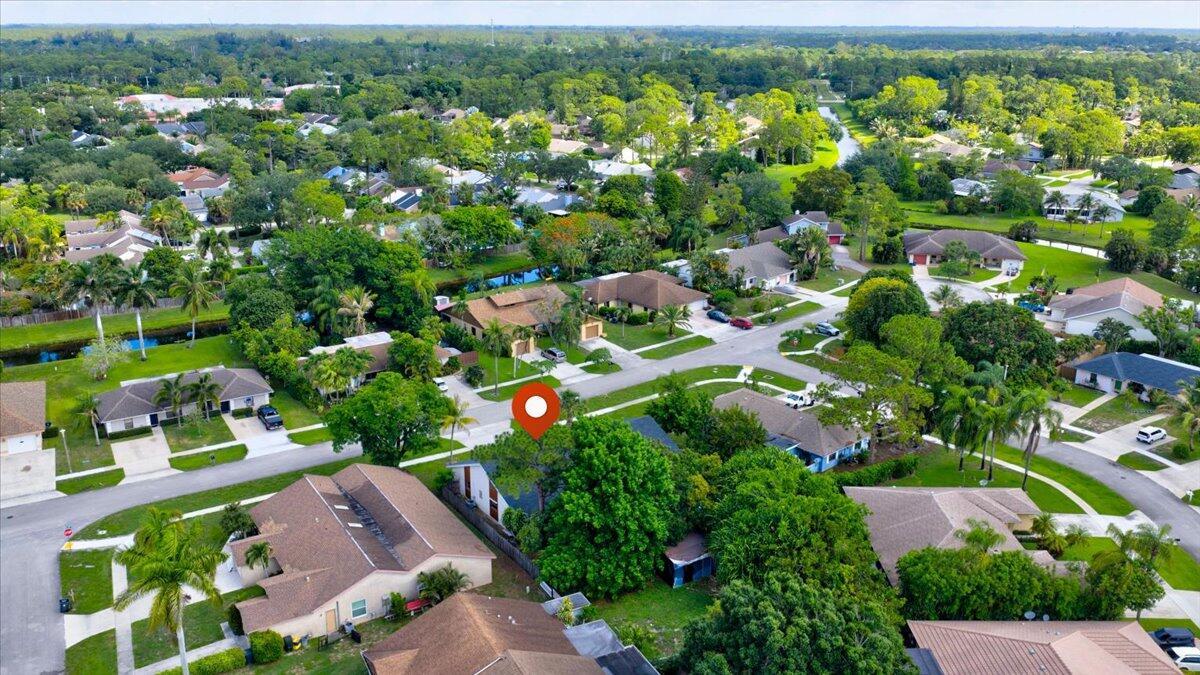 An aerial view of a suburban neighborhood featuring single-family homes, lush trees, and paved streets — 12452 Guilford Way, Wellington FL 33414, WELLINGTON, FL