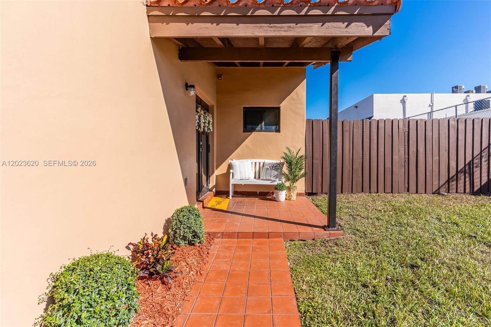A tiled walkway leads to a covered patio with a white bench and potted plant — 3815 SW 82nd Ave # 41, Miami FL 33155, MIAMI, FL