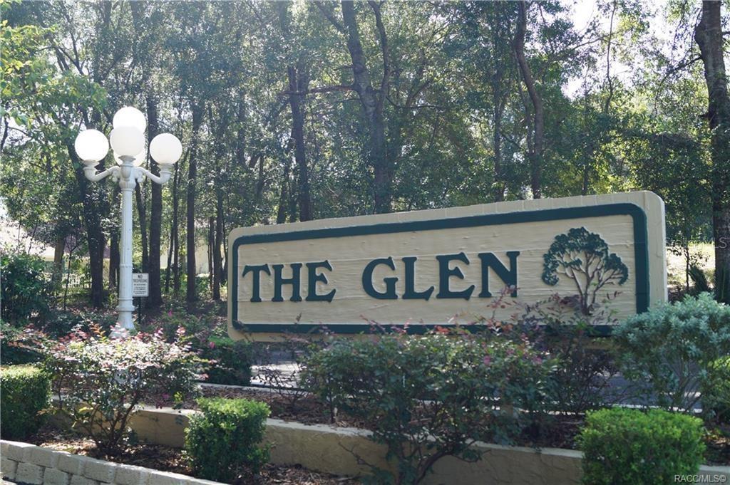A sign reading The Glen stands in front of a wooded area with a lamppost — 3505 N WOODGATE DRIVE, BEVERLY HILLS, FL