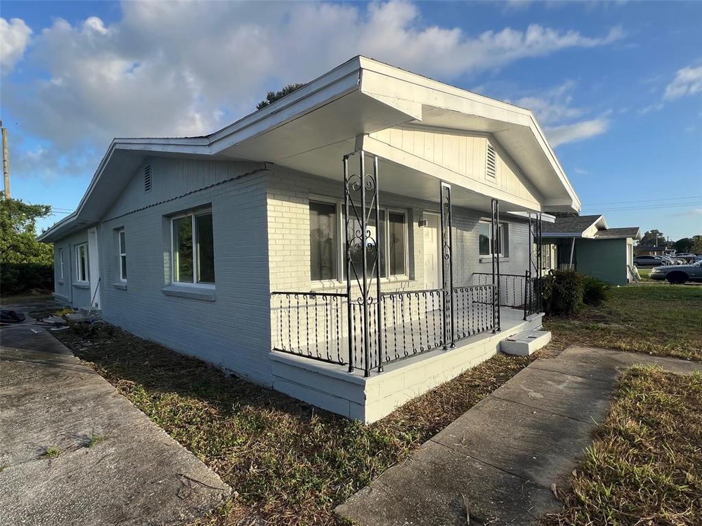 A single-story gray brick house features a front porch with decorative black metal railings — 614 PAW PAW STREET, COCOA, FL