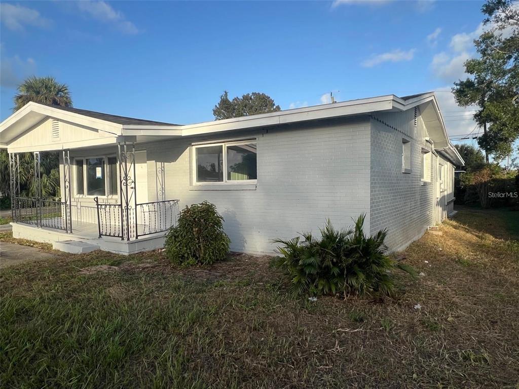 A single-story gray brick house features a front porch with decorative metal railings — 614 PAW PAW STREET, COCOA, FL