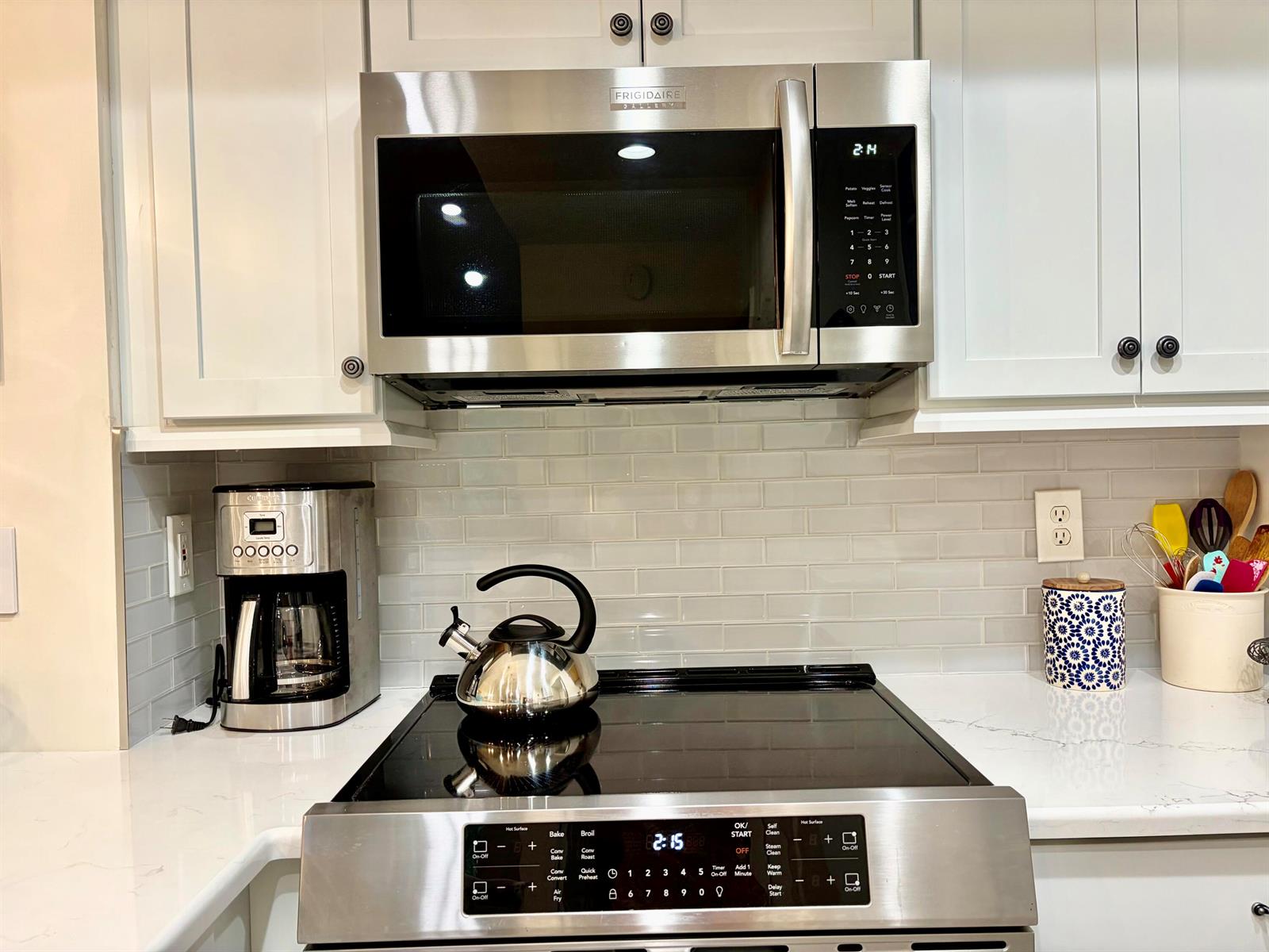 A stainless steel microwave and stove are installed in a kitchen with white cabinets — 242 Village Boulevard # 2304, Tequesta FL 33469, TEQUESTA, FL