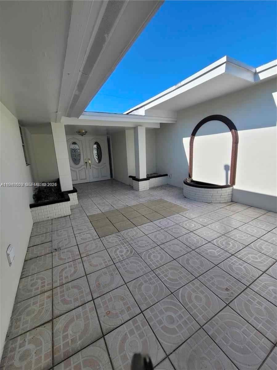 An outdoor tiled courtyard features a double front door, a fountain, and a partial roof — 12305 SW 42nd St, Miami FL 33175, MIAMI, FL