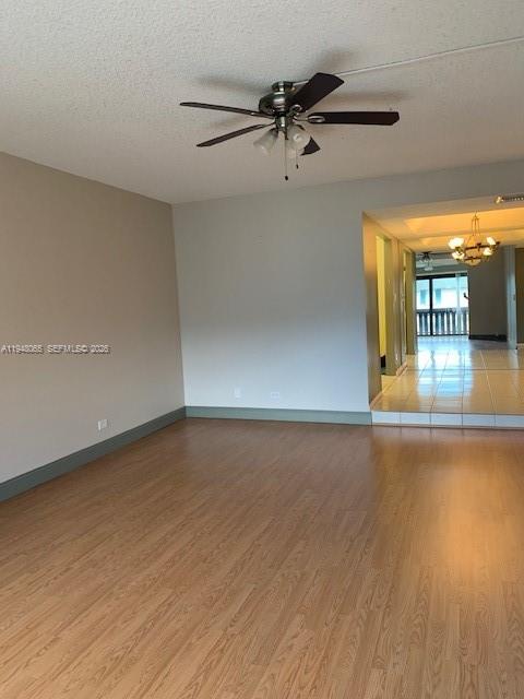 A living room with wood-look flooring, a ceiling fan, and a view into another room — 3710 Inverrary Dr # 3K, Lauderhill FL 33319, LAUDERHILL, FL
