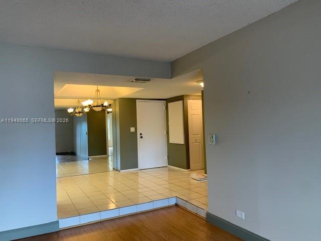 An interior view shows a tiled entryway with a chandelier leading to a living area — 3710 Inverrary Dr # 3K, Lauderhill FL 33319, LAUDERHILL, FL