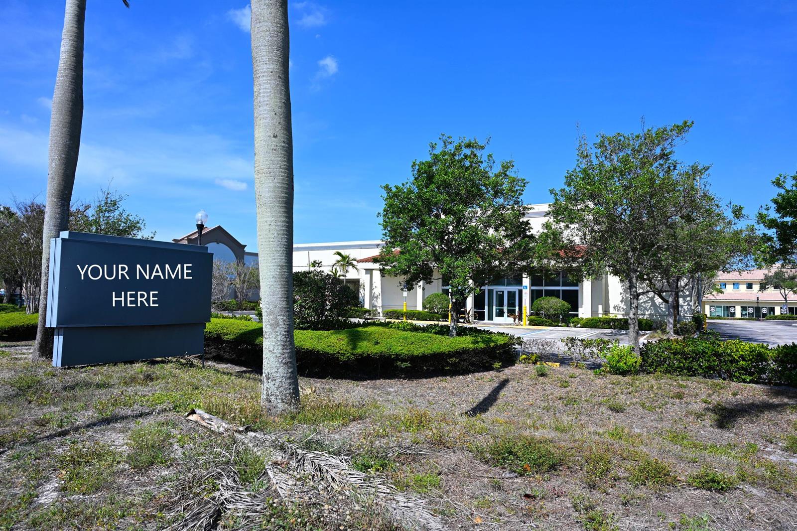 A commercial building with a blank sign in the foreground and surrounding landscaping — 150 Tequesta Drive, Tequesta FL 33469, TEQUESTA, FL