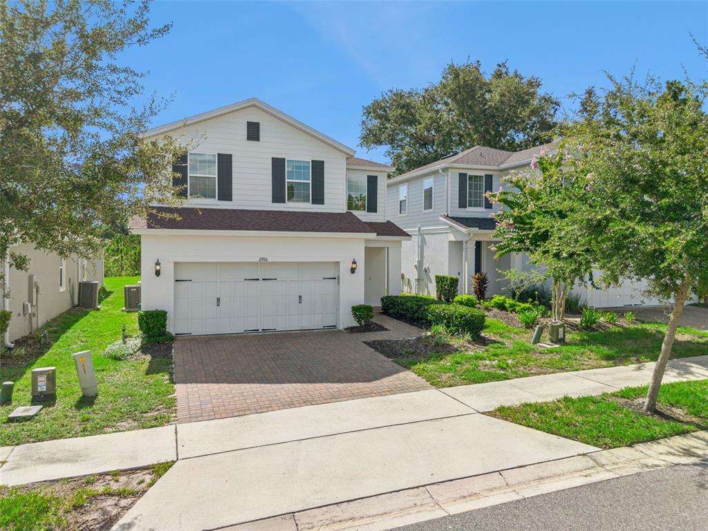 A two-story house with white siding, a two-car garage, and a brick paver driveway — 2766 BOBCAT CHASE BOULEVARD, WINTER GARDEN, FL