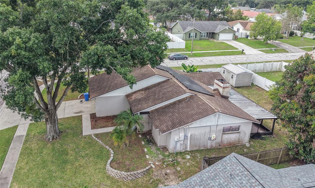 An aerial view shows a single-story house with a brown roof and a large tree — 1702 SOUTHWIND DRIVE, BRANDON, FL
