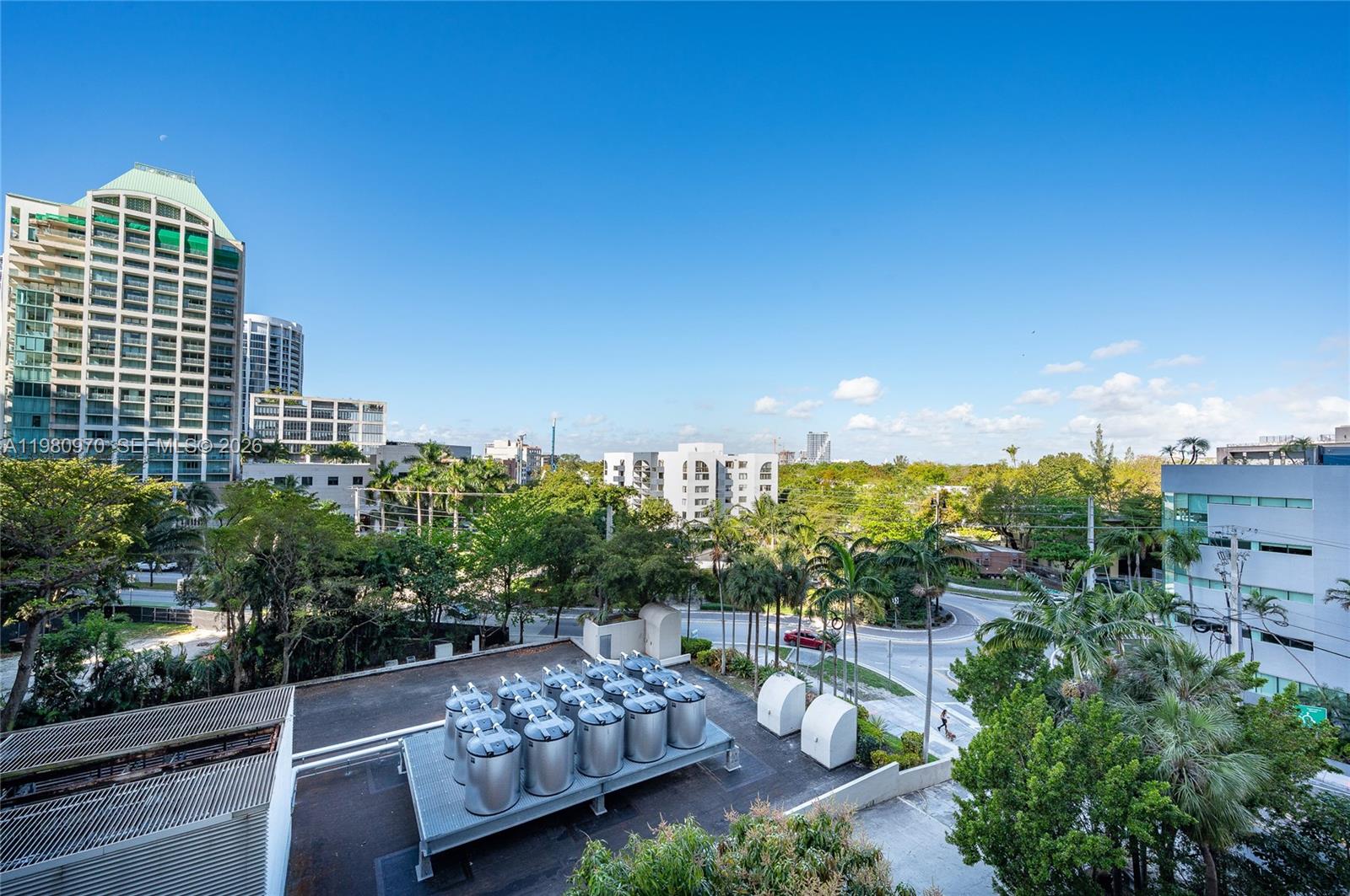 An elevated view shows a rooftop with HVAC units overlooking a street, trees, and buildings — 2678 Tigertail Ave # 413, Miami FL 33133, MIAMI, FL