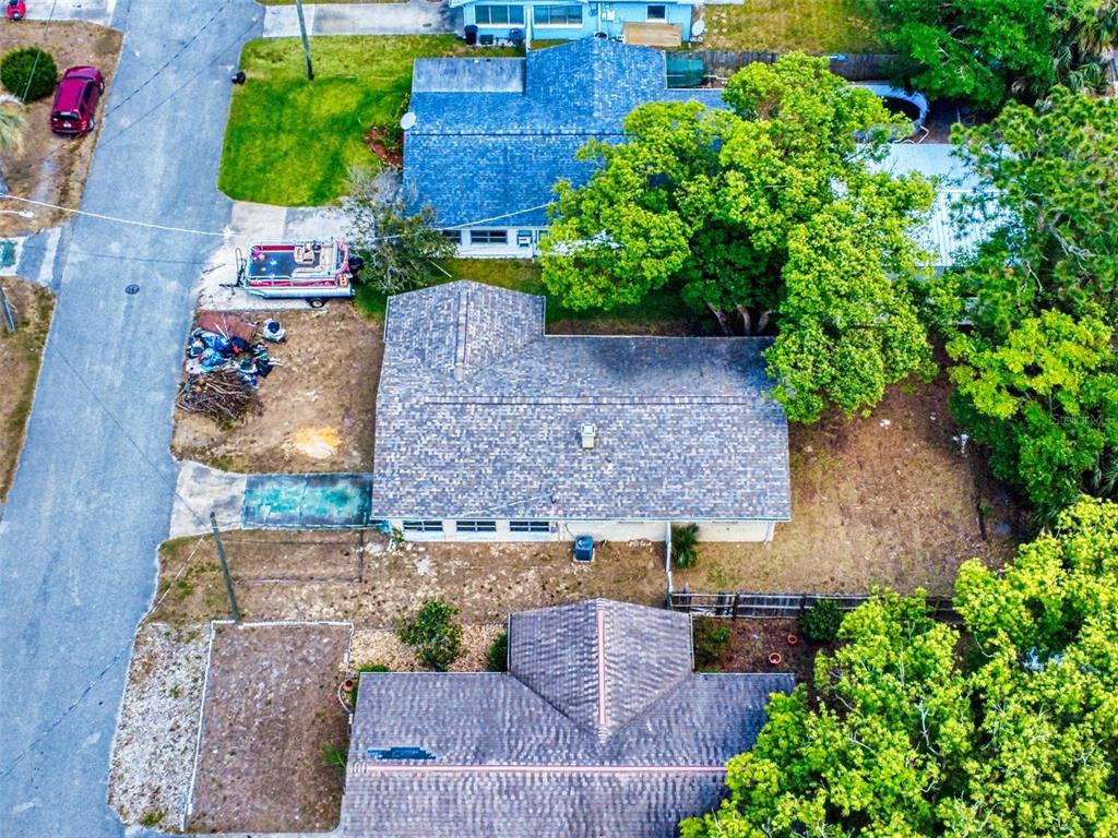 An aerial view shows two residential houses with shingled roofs, trees, and a parked boat — 310 LEGION PLACE, PORT ORANGE, FL