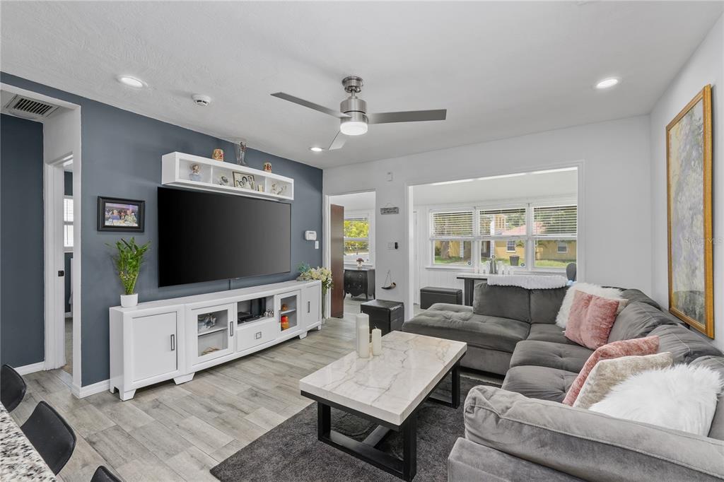 A living room features a grey accent wall, a large sectional sofa, and a television console — 3260 36TH AVENUE N, ST PETERSBURG, FL