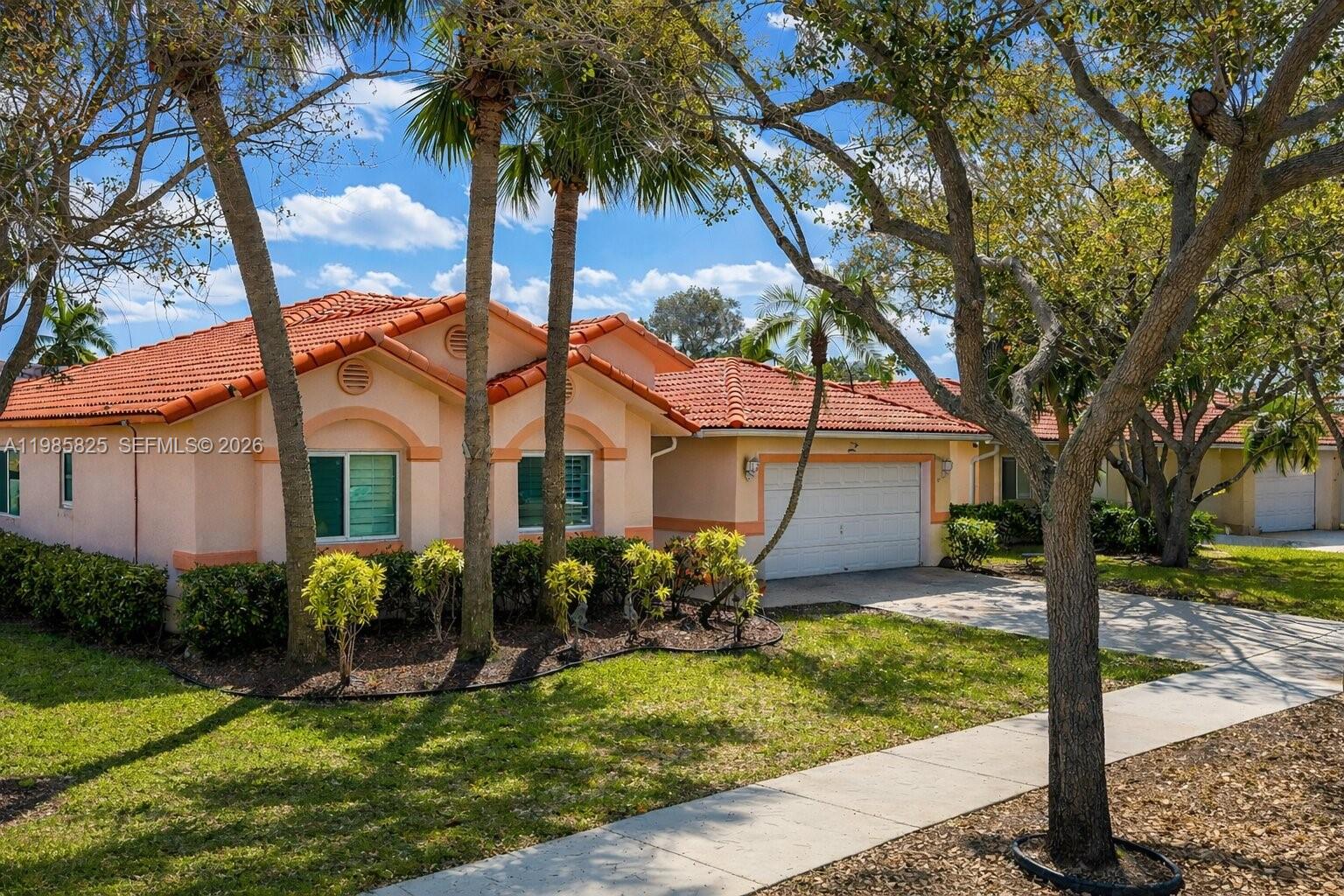 A single-story house with a terracotta tile roof, peach stucco walls, and a garage — 16898 Crestview Ln, Weston FL 33326, WESTON, FL