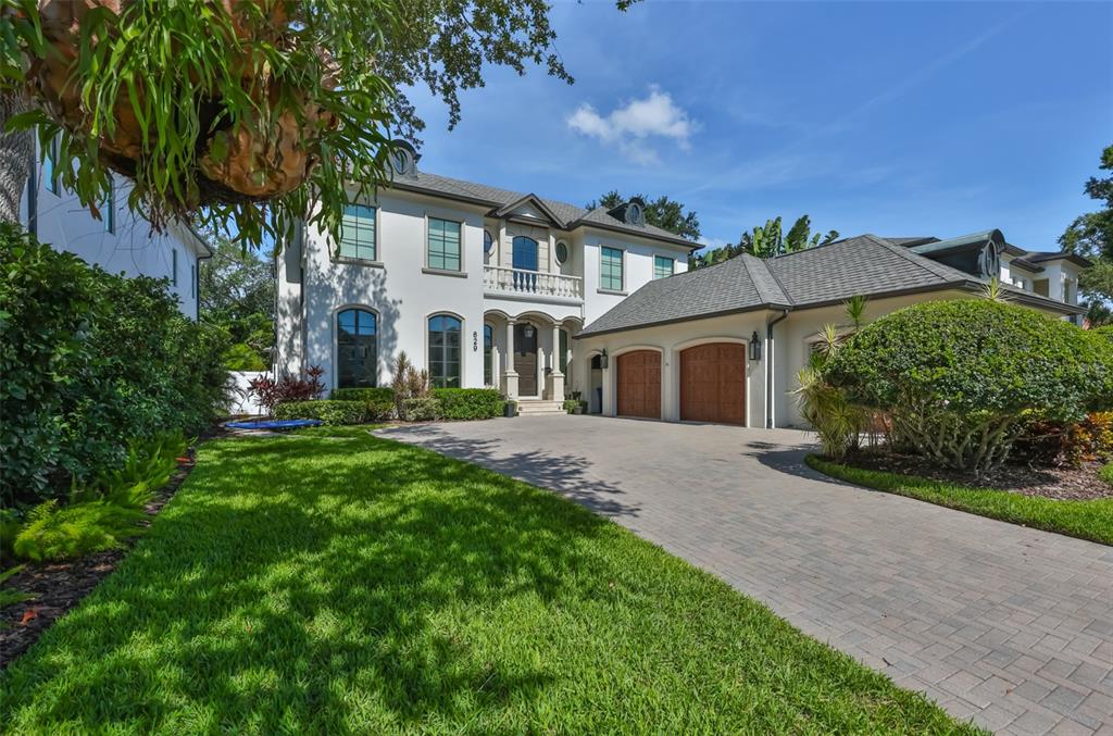 A two-story stucco house with a paved driveway and a three-car garage — 629 RIVIERA DRIVE, TAMPA, FL