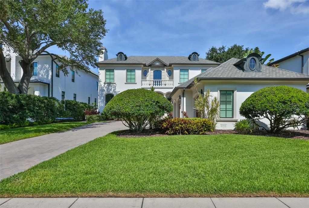 A two-story white house with a gray shingled roof and a paved driveway — 629 RIVIERA DRIVE, TAMPA, FL