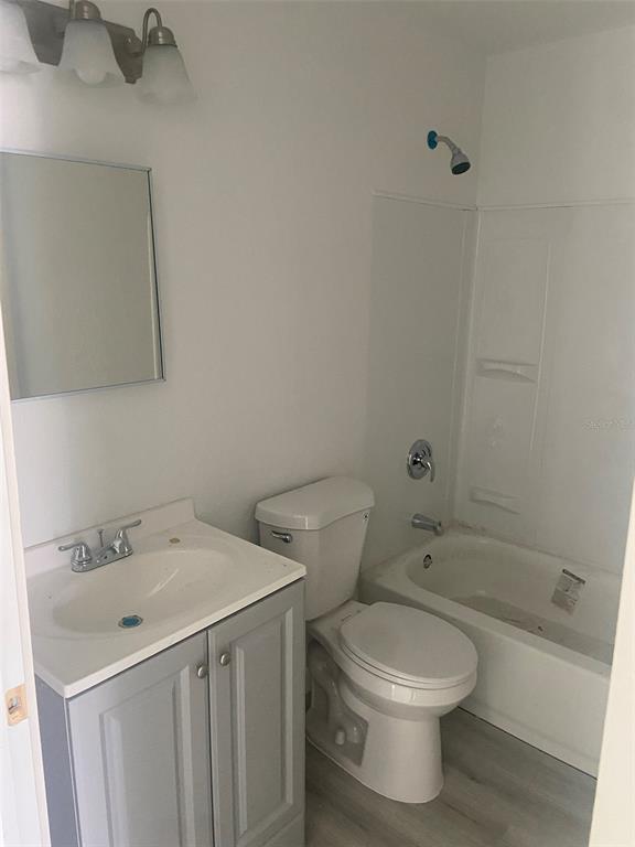 A bathroom features a gray vanity, a white toilet, and a shower-tub combination — 3490 13TH AVENUE S, ST PETERSBURG, FL